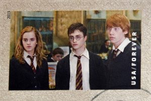 27028704 - united states of america - circa 2013: a stamp printed in usa dedicated to harry potter shows hermione granger, harry potter, and ron weasley, circa 2013